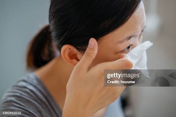 young asian woman removing makeup with makeup remover wipe - eye make up stock pictures, royalty-free photos & images