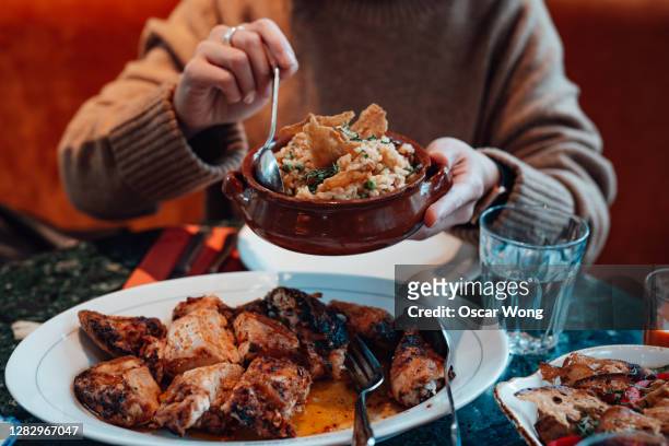 young woman sharing food with friends at restaurant - portuguese culture stock pictures, royalty-free photos & images