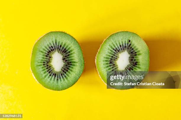 half kiwi pieces on yellow background - kiwi fruit 個照片及圖片檔