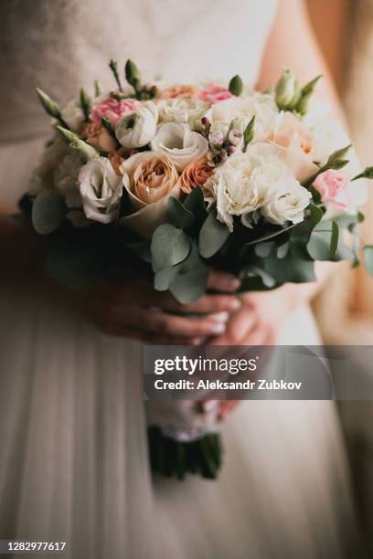 beautiful bouquet with pink and white roses in the hands of a girl or woman. the bride in a luxurious expensive elegant dress holds a wedding bouquet in her hands. - bouquet foto e immagini stock