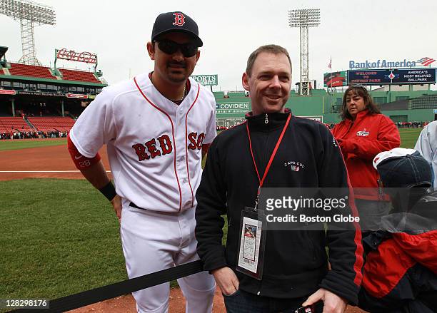 Boston Red Sox first baseman Adrian Gonzalez poses with fan Ken Griffin, during today's Red Sox On-Field Photo Day festivities prior to the start of...