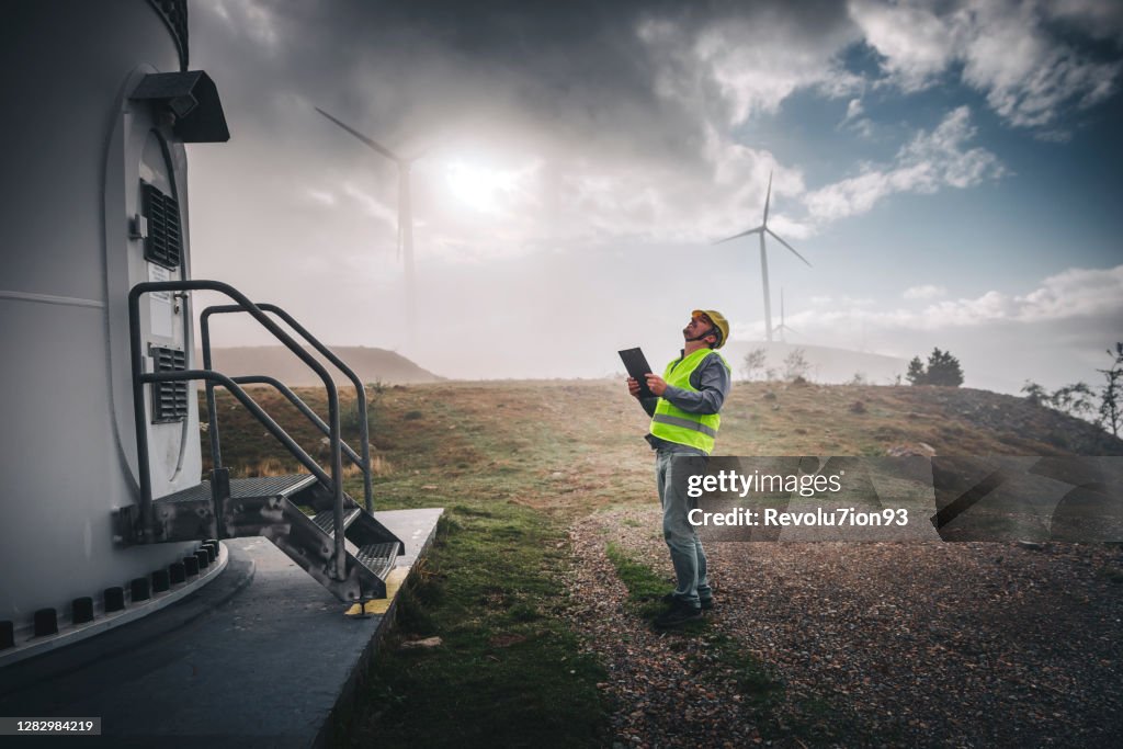 Young engineer man looking and checking wind turbines