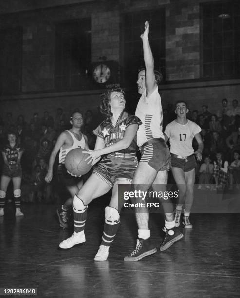 Player of 'All American Red Heads', the first professional women's basketball team, in action during a match against an all-male team, Long Island,...