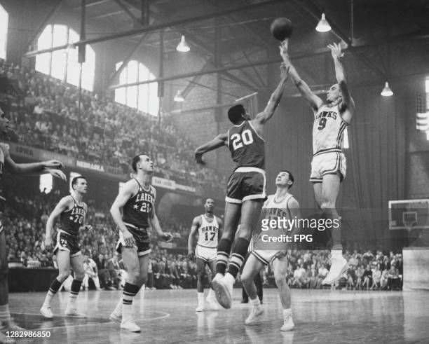 American basketball player Tom Hawkins , #20 for Los Angeles Lakers, attempts to block American basketball player Bob Pettit, #9 for St Louis Hawks ,...