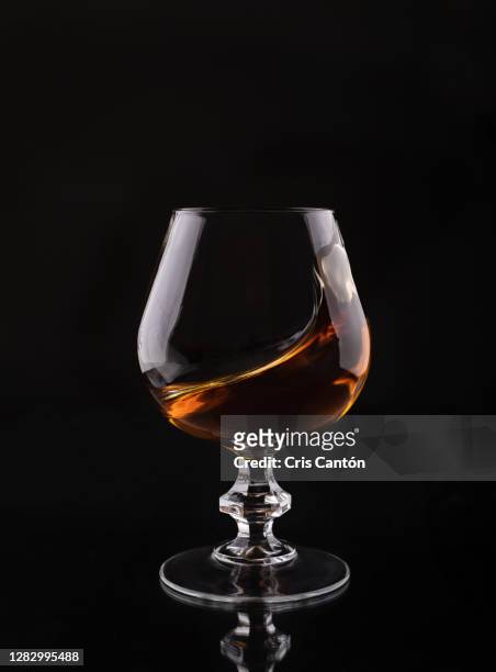 brandy glass on black background swirling - cognac fotografías e imágenes de stock