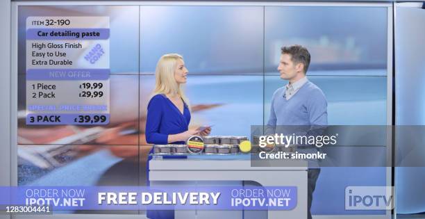 female and male television presenters advertising car wax - television advertisement stock pictures, royalty-free photos & images