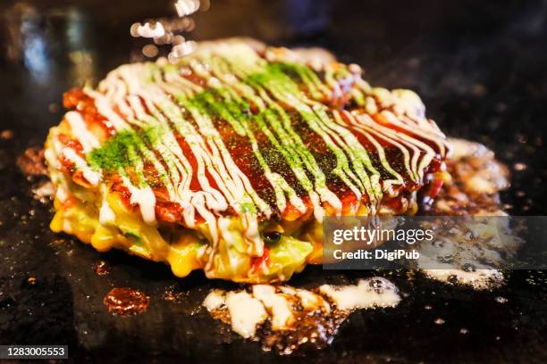 okonomiyaki on griddle - okonomiyaki stock pictures, royalty-free photos & images