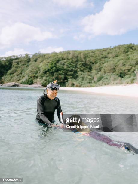 grandfather teaching granddaughter how to snorkel - okinawa islands stock pictures, royalty-free photos & images