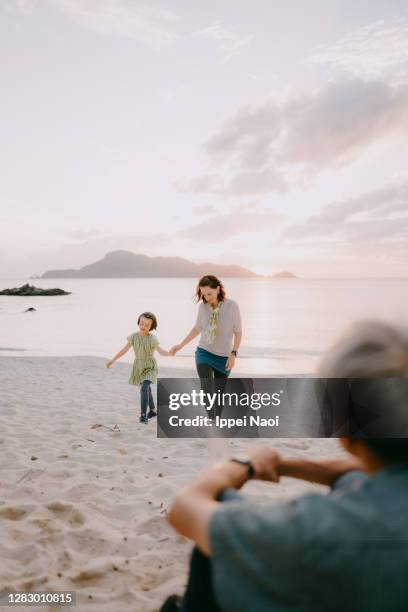 mother and daughter walking on beach at sunset, japan - eurasian ethnicity stock pictures, royalty-free photos & images