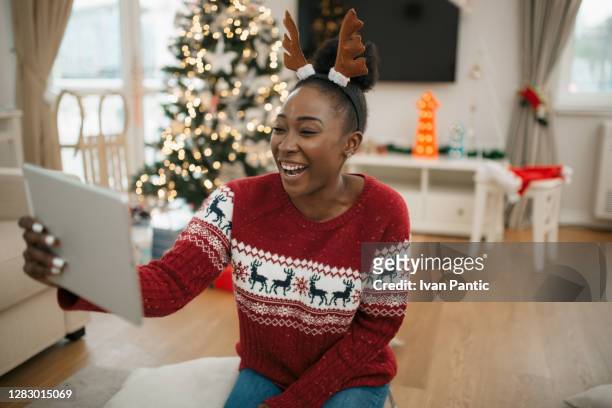 happy young african american woman celebrating christmas at home - virtual vacations stock pictures, royalty-free photos & images