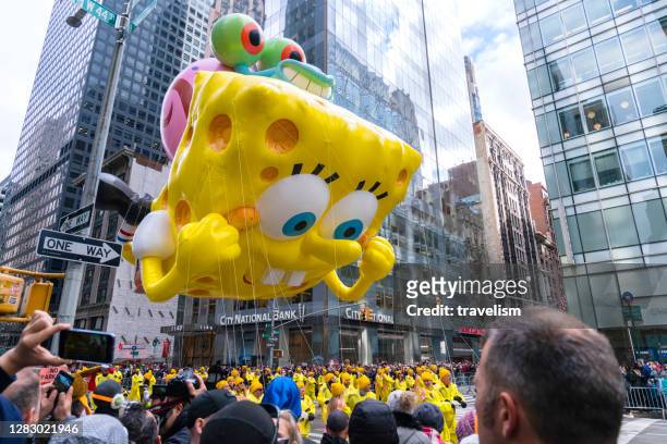 spongebob squarepants balloon floats down central park at annual macy's thanksgiving day parade - parada militar imagens e fotografias de stock