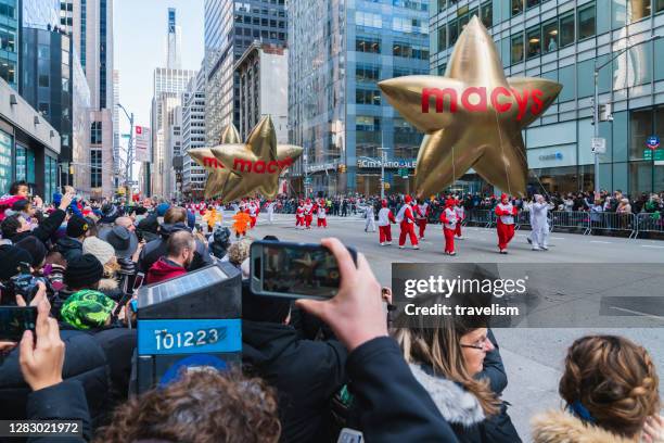 les ballons macy’s star sont pilotés avec deux étoiles près de columbus circle annual macy’s thanksgiving day parade. - macys parade photos et images de collection