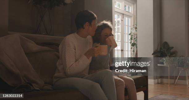 erzählen sie mir von ihrem tag... - family on couch with mugs stock-fotos und bilder