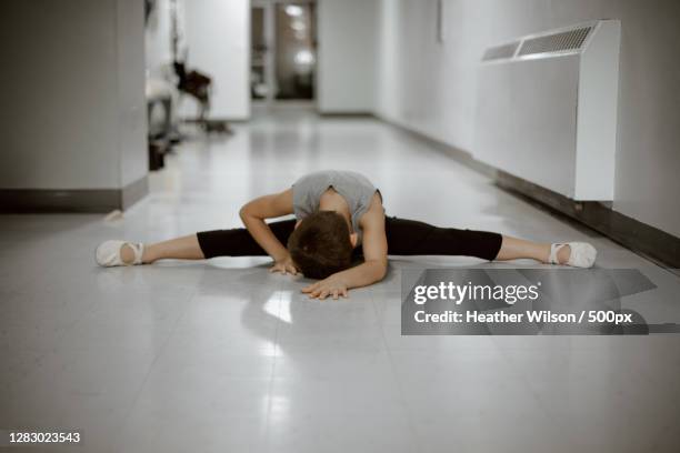 young caucasian boy stretching and warming up for ballet,freeport,il,united states,usa - freeport illinois stockfoto's en -beelden