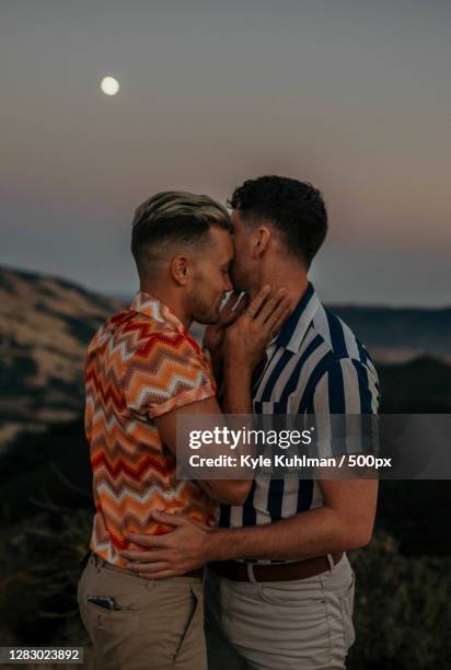 young caucasian lgbtqi couple kissing each other romantically - gay couple kissing fotografías e imágenes de stock