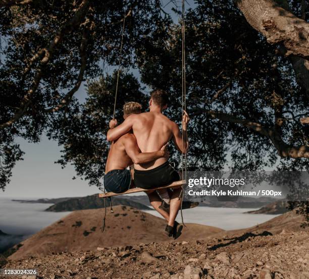 young caucasian lgbtqi couple sitting together romantically outdoors - tcs stock pictures, royalty-free photos & images