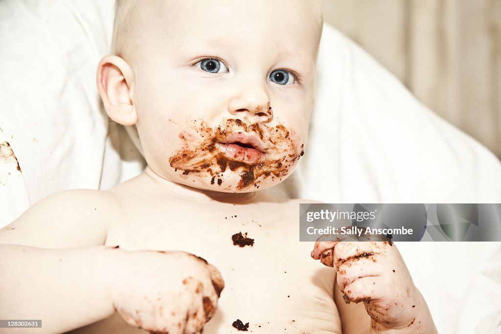 Baby boy eating chocolate cake