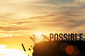 Businessman push impossible wording to possible wording on top of mountain with sunlight. Positive mindset concept.