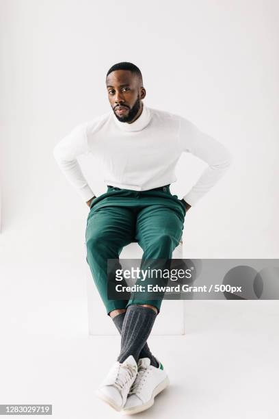 portrait of a stylish adult african american man sitting - sitting stock pictures, royalty-free photos & images