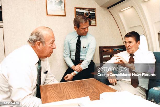 On board Air Force One , from left, American politician and US Secretary of State George P Shultz and National Security Advisor-designate Robert...