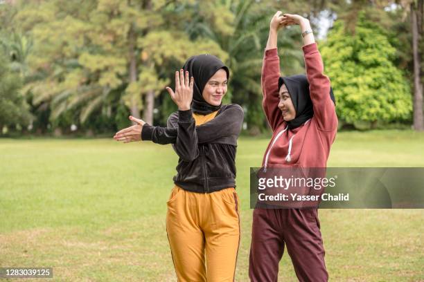 two girls stretching exercise - kids fun indonesia stock pictures, royalty-free photos & images
