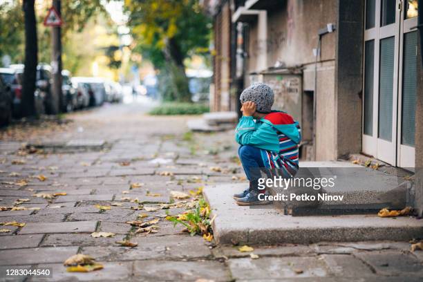 menino sentado sozinho na rua - center street elementary - fotografias e filmes do acervo