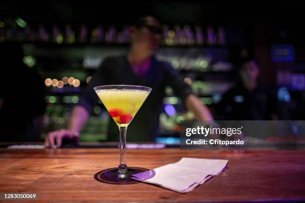 martini cosmopolitan and a bartender - bar front stock-fotos und bilder