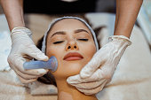 Woman having a facial cupping treatment in the beauty clinic