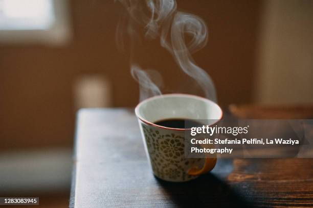 coffee cup with hot steam on wooden table. - week stockfoto's en -beelden