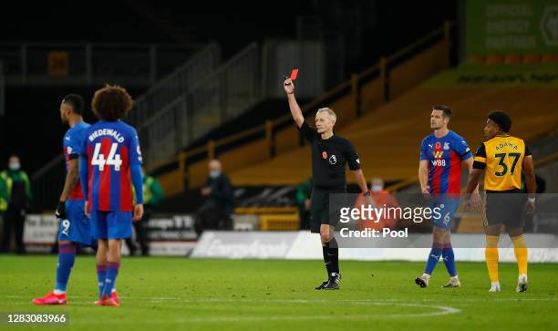Referee Martin Atkinson awards Luka Milivojevic of Crystal Palace a red card following a VAR review during the Premier League match between...