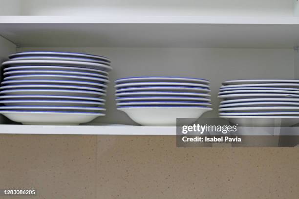 tablewares in cupboard - blue plate stock pictures, royalty-free photos & images