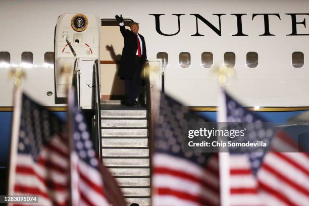 President Donald Trump waves from the steps of Air Force one after delivering a brief speech to supporters during a campaign rally at Rochester...