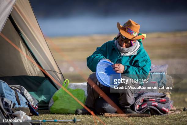 lokale quechua mann reparatur sieb weißen camping reisen durch abgelegene berge. - quechua stock-fotos und bilder