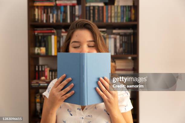 young woman holding book in her hands - book hand stock pictures, royalty-free photos & images