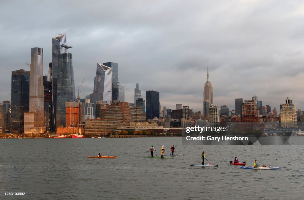 Paddle-boarders Float in the Hudson River at Sunset in New York City