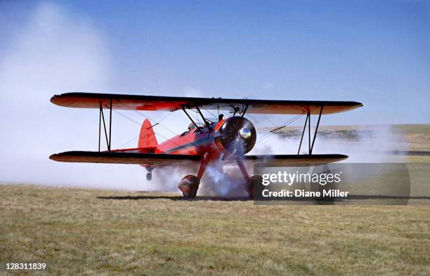 red stearman bi-plane taking off with air show smoke - 1930 stock pictures, royalty-free photos & images