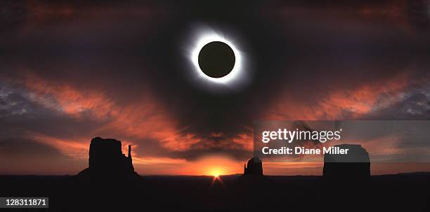 total solar eclipse and monument valley at sunrise, utah, usa - verduistering stockfoto's en -beelden