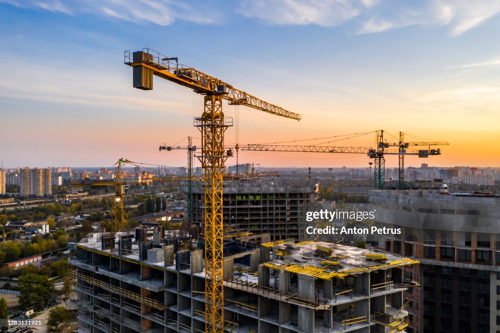 Construction site with cranes at sunset. Construction of an apartment building
