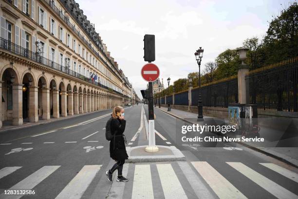 Woman walks along empty Rue de Rivoli on the first day of a nationwide lockdown confinement on October 30, 2020 in Paris, France.