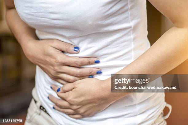 woman stomach pain due to disease - farting foto e immagini stock