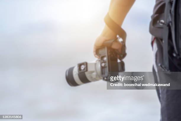 photographer is holding a camera / blur focus - spiegelreflexcamera stockfoto's en -beelden