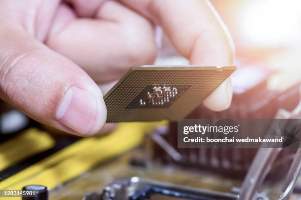 technician plug in cpu microprocessor to motherboard socket - computer repair background stock pictures, royalty-free photos & images