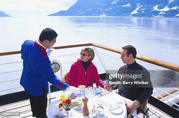 waiter serving a couple on deck of cruise ship, ak - cruise deck stock pictures, royalty-free photos & images