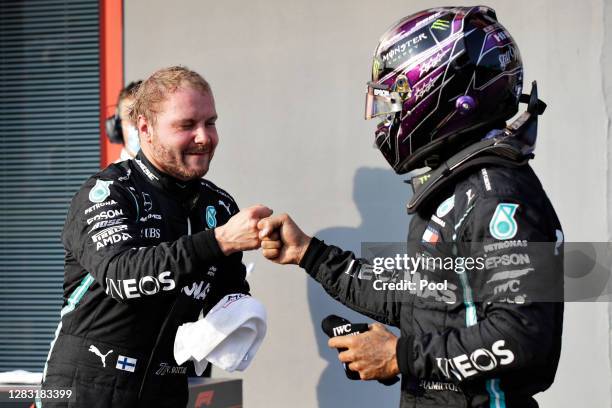 Pole position qualifier Valtteri Bottas of Finland and Mercedes GP bumps fists with second place qualifier Lewis Hamilton of Great Britain and...