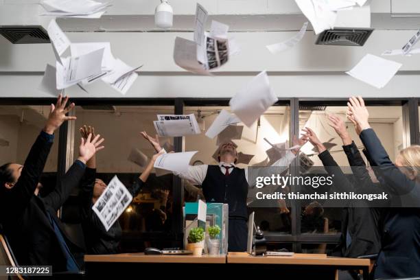 shot of cheerful business team throwing papers up in the air at office. - report fun stock pictures, royalty-free photos & images