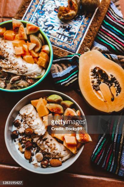 ciotole di frullato di papaia ricche di antiossidanti condite con banana, fichi freschi e noci - papaia foto e immagini stock