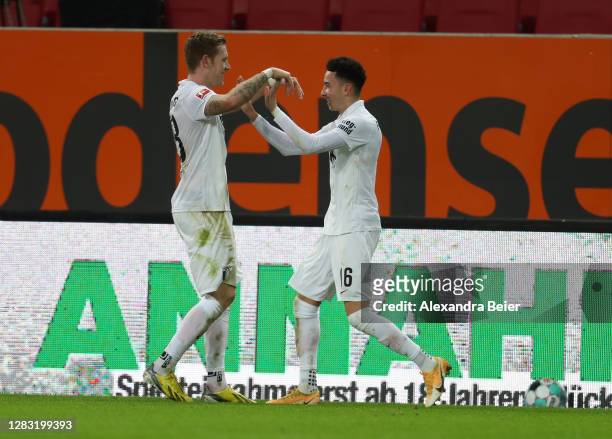 Andre Hahn of FC Augsburg celebrates with teammate Ruben Vargas after scoring his team's second goal during the Bundesliga match between FC Augsburg...
