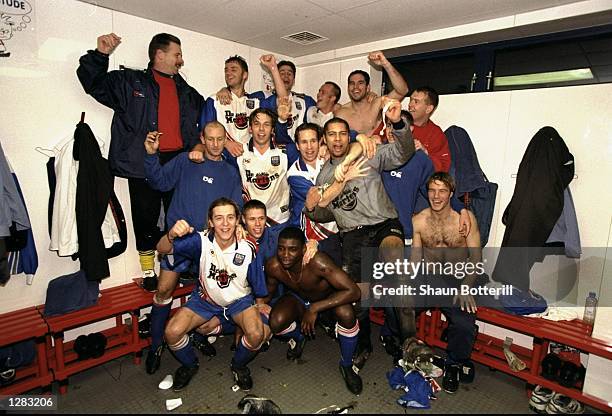 The Rushden and Diamonds team celebrates in the locker room after winning the FA Cup Round 2 Replay match against Doncaster at Nene Park,...