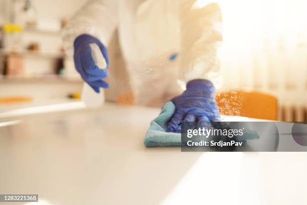 close-up of an unrecognizable person spraying and disinfecting table with manual sprayer - office cleaning stock pictures, royalty-free photos & images