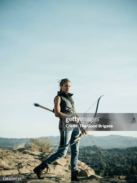 woman hunting with bow and arrow - arco y flecha fotografías e imágenes de stock